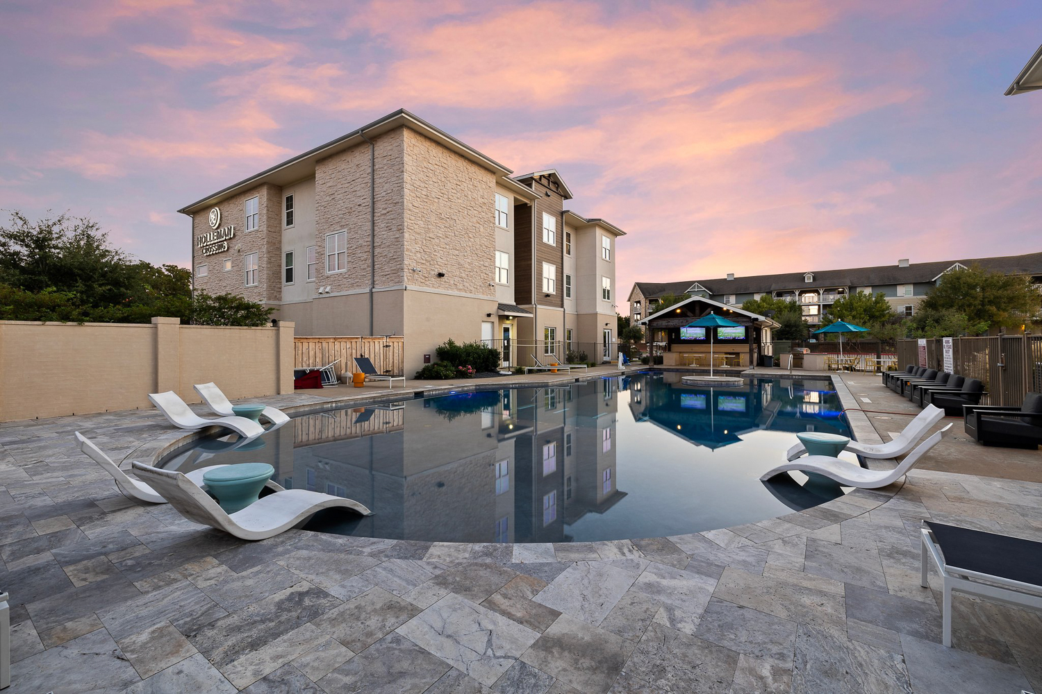 holleman crossing apartments near texas am pool and outdoor lounge cabana at sunset